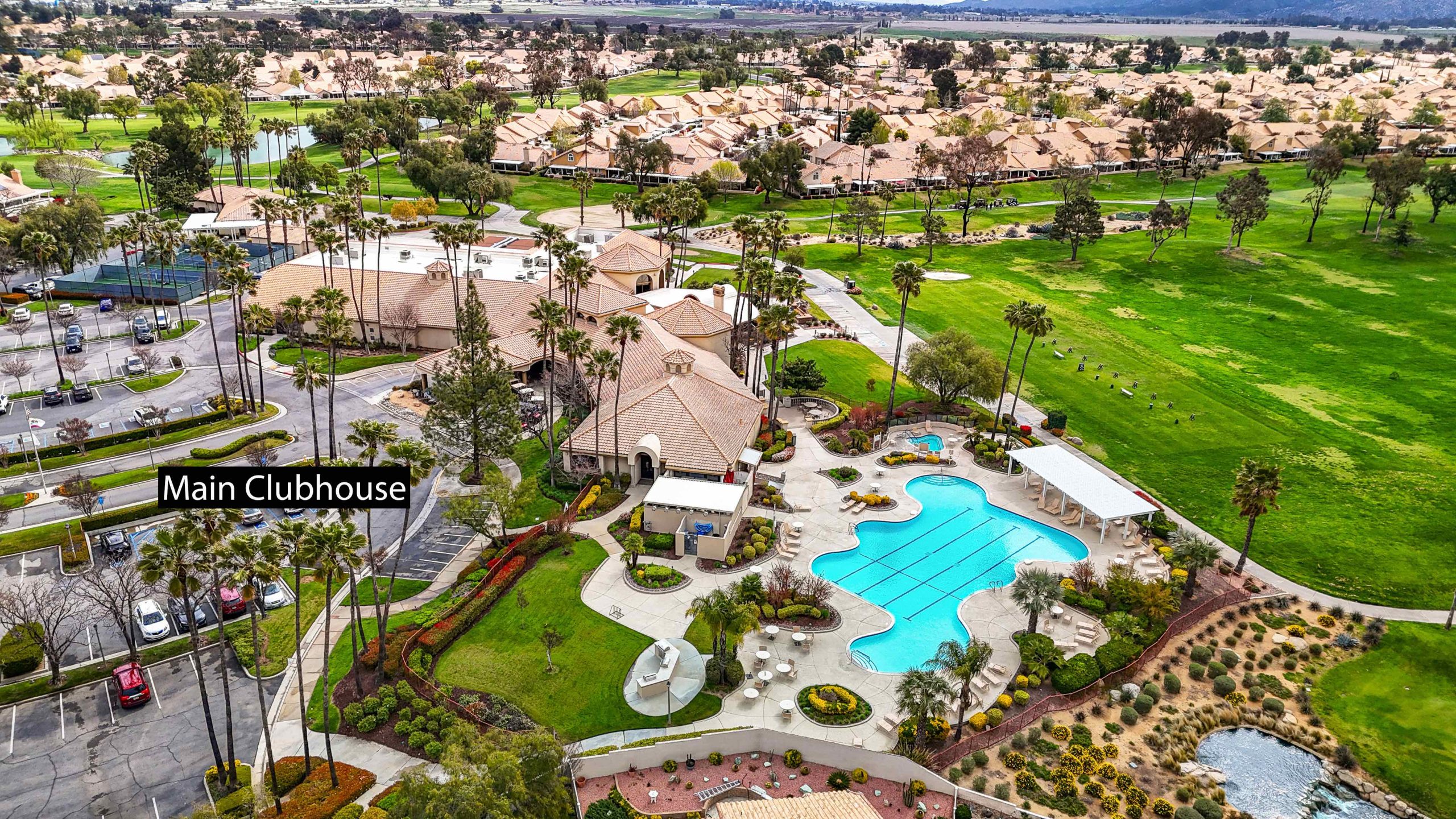 Aerial view of Sun Lakes Country Club showing the main clubhouse, outdoor pool, golf course, and surrounding homes in Banning, CA.